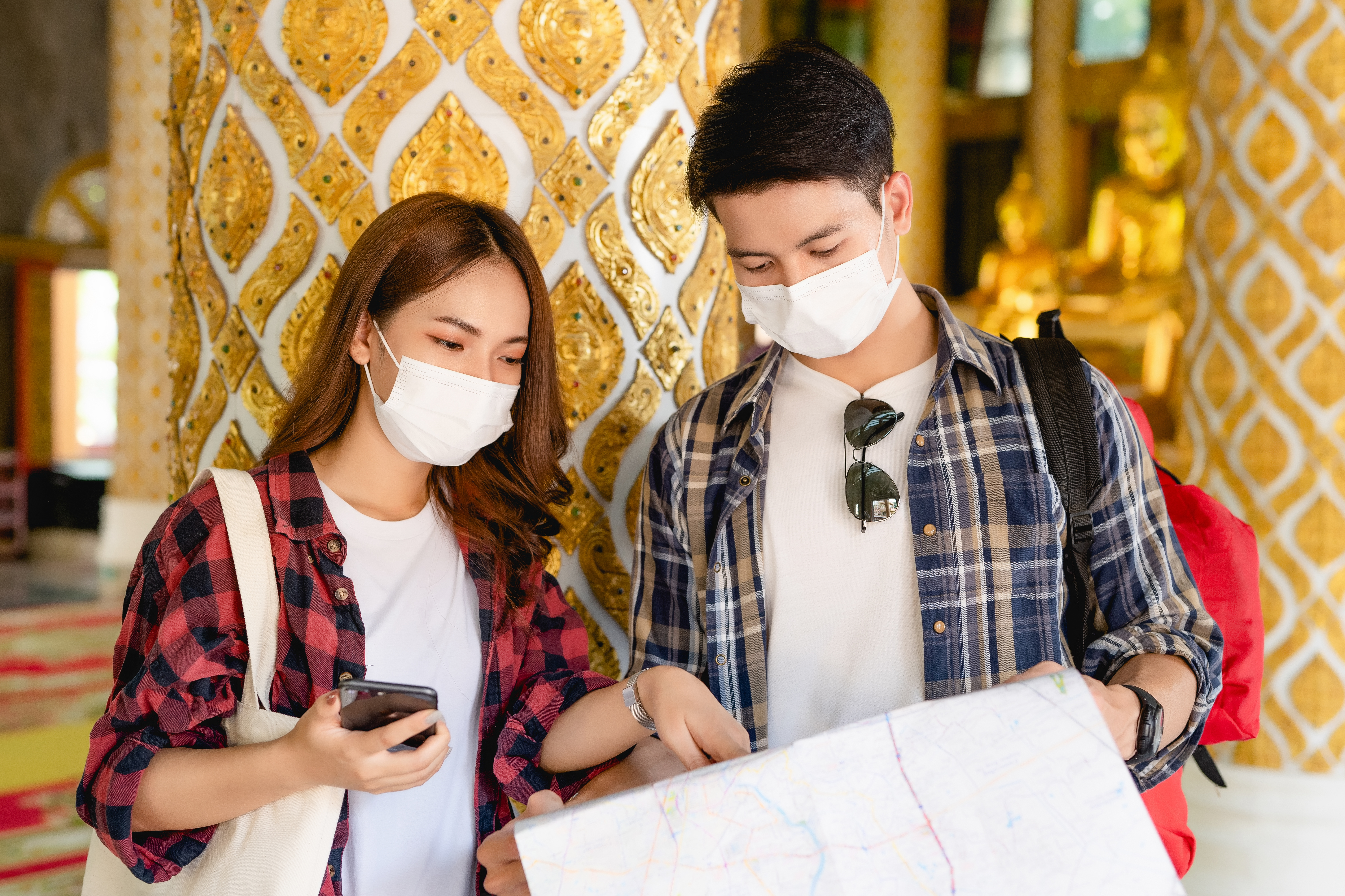 asian-couple-tourist-backpackers-standing-beautiful-thai-temple-pretty-woman-holding-smartphone-handsome-man-check-paper-map-travel-vacations